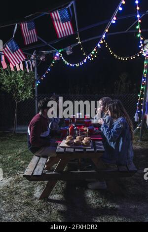 Groupe de jeunes Espagnols appréciant leur temps pendant un pique-nique barbecue le jour de l'indépendance des États-Unis la nuit Banque D'Images