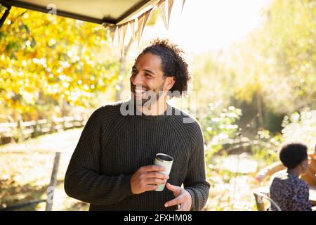 Un homme heureux avec un café dans un parc d'automne ensoleillé Banque D'Images