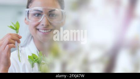 Composition d'une scientifique souriante tenant un tube à essai avec une plante et l'espace de copie Banque D'Images