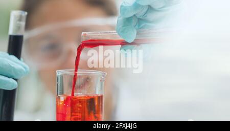 Composition de la scientifique femelle tenant le tube à essai avec le liquide rouge en laboratoire et dans l'espace de copie Banque D'Images