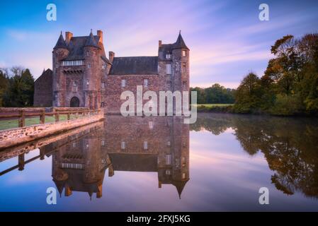 FRANCE, BRETAGNE, MORBIHAN (56) , CAMPENEAC, CHÂTEAU DE TRECESSON AVEC SON REFLET DANS L'ÉTANG AU LEVER DU SOLEIL Banque D'Images