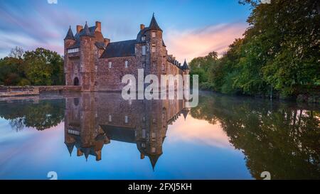 FRANCE, BRETAGNE, MORBIHAN (56) CAMPENEAC, CHÂTEAU DE TRECESSON AVEC SON REFLET DANS L'ÉTANG AU LEVER DU SOLEIL Banque D'Images