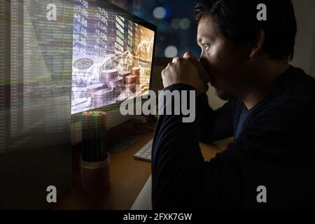 Portrait d'un homme d'affaires asiatique assis et travaillant dur sur le Tableau avec graphique de négociation sur le paysage urbain et avec programmation code source dans hologramme dans Banque D'Images