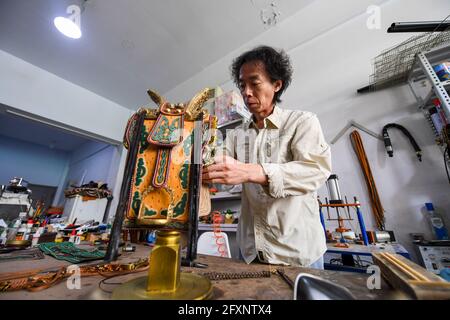 (210527) -- XILINHOT, 27 mai 2021 (Xinhua) -- Xilinhu fait un artisanat en forme de selle à son atelier de Xilinhot, dans la région autonome de la Mongolie intérieure de la Chine du nord, le 26 mai 2021. L'équitation, le tir à l'arc et la lutte sont appelés les trois compétences des hommes du groupe ethnique mongol. Depuis 2005, le handicapeur Xilinhu du groupe ethnique mongol a impliqué les symboles culturels de selle, d'arc et de flèche et de costume de lutte dans la fabrication de l'artisanat pour promouvoir la culture traditionnelle du groupe ethnique. (Xinhua/Peng Yuan) Banque D'Images