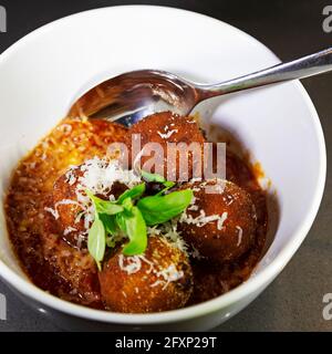 Arancini dans la sauce tomate. Le plat est un exemple populaire de la cuisine italienne. Banque D'Images