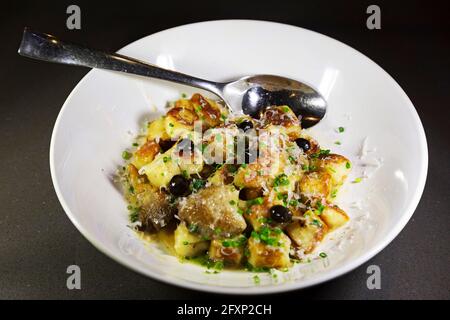 Gnocchi cuits avec des olives et du parmesan râpé. Le plat est arrosé d'huile d'olive. Banque D'Images