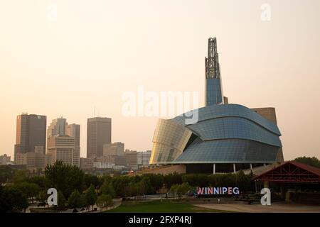 L'horizon de Winnipeg, Canada, vu en soirée. Le Musée canadien des droits de la personne se trouve à droite de la scène urbaine. Banque D'Images