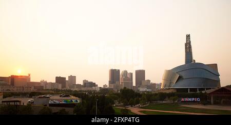 Coucher de soleil sur la ligne d'horizon de Winnipeg, Canada. Le Musée canadien des droits de la personne se trouve à droite de la scène urbaine. Banque D'Images