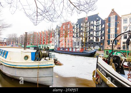 Maisons colorées de style rétro sur le canal de Damrak, Amsterdam, la Hollande du Nord, les pays-Bas, l'Europe Banque D'Images