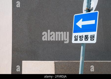 Panneau de signalisation à sens unique et mur gris en Corée Banque D'Images