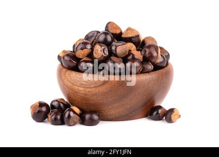 Graines de guarana dans un bol en bois, isolées sur fond blanc. Supplément alimentaire guarana, source de caféine pour boissons énergétiques. Banque D'Images