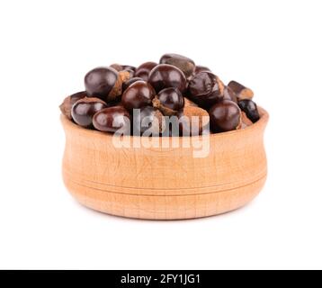 Graines de guarana dans un bol en bois, isolées sur fond blanc. Supplément alimentaire guarana, source de caféine pour boissons énergétiques. Banque D'Images