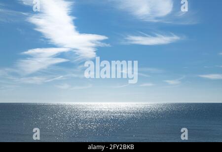 Formation de nuages au-dessus de la mer avec réflexions de la lumière du soleil. Banque D'Images