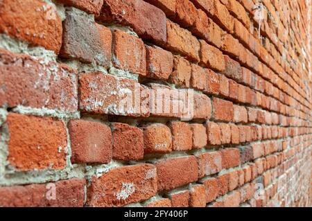 Mur de briques rouges avec perspective décroissante. Fragment de mur de brique marron avec une faible profondeur de champ. Vue en angle avec vue sur une allée de briques Banque D'Images