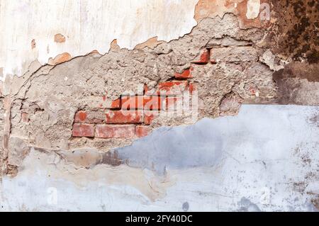 Murs en briques rouges rétro et grungeux avec stuc gris blanc cassé. Vue de la clôture en plâtre érodée et endommagée. Structure murale vintage avec plâtre Banque D'Images