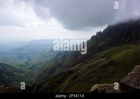 Vue sur une vallée isolée dans les montagnes du Drakensberg en Afrique du Sud, avec les hauts sommets cachés par les nuages de tempête de rassemblement. La vite cha Banque D'Images