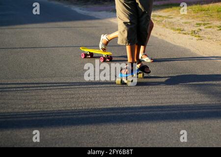 Redéfinit les enfants jouant sur le skateboard dans la rue. Les enfants de race blanche à la planche de Penny, à la pratique du skateboard. Concept d'enfance et d'amitié Banque D'Images