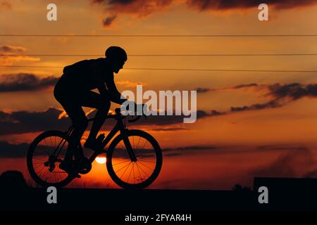 Cycliste sportif dans la course de silhouette sur route Banque D'Images