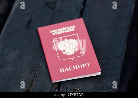 Le passeport russe se trouve sur une poutre de bois brûlée. Maison brûlée. Photo de haute qualité Banque D'Images