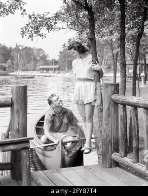 ADOLESCENT DES ANNÉES 1940 EN CANOË PARLANT À L'ADOLESCENTE DEBOUT SUR LE QUAI DU LAC DU CAMP D'ÉTÉ - C1996 HAR001 HARS RELATION VIEUX TEMPS NOSTALGIE VIEILLE MODE 1 SHORT DE FITNESS JUVÉNILE STYLE DE COMMUNICATION SAINE JEUNE ADULTE CANOË ATHLÈTE JOIE MODE DE VIE FEMMES SANTÉ RURALE ATHLÉTISME AMITIÉ PERSONNES SOINS DOCK HOMMES ADOLESCENTE FILLE TRANSPORT ATHLÉTIQUE POUR GARÇON ADOLESCENT B&W ESTIVAL DATING ACTIVITÉ AU BORD DU LAC BONHEUR PHYSIQUE RUSTIQUE JOURNAUX DE FORCE RÉCRÉATION ATTRACTION CHEMISIER RELATIONS CONNEXION COUR ATHLÈTES FLEXIBILITÉ MUSCLES ÉLÉGANT ADOLESCENTS POSSIBILITÉ COOPÉRATION JEUNES Banque D'Images