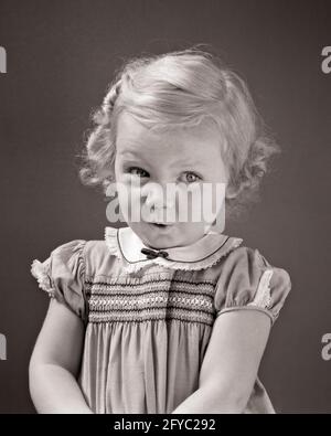 ANNÉES 1930 BLONDE JEUNE FILLE DES ANNÉES 1940 REGARDANT L'APPAREIL PHOTO VERS LE HAUT ET SUR LE CÔTÉ TIMIDE BASHFUL EXPRESSION DU VISAGE PORTANT LA ROBE AVEC SMOCKING - J3100 HAR001 HARS VIE VIE COPIE ESPACE DEMI-LONGUEUR EXPRESSIONS B&W CONTACT VISUEL DÉCOUVERTE DU BONHEUR ET VERS LE HAUT TIMIDE AGRÉABLE ADORABLES JEUNES ADORABLES ADORABLES ADORABLE BÉBÉ ATTRAYANT FILLE BASHFUL NOIR ET BLANC DE RACE BLANCHE HAR001 OLD FASHIONED SMACKING Banque D'Images