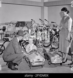 ANNÉES 1950 FAMILLE HEUREUSE DANS MAGASIN DE JOUETS GARÇON ASSIS DANS LE MÉTAL PÉDEZ LA VOITURE AVEC LE PÈRE AGENOUILLÉ À CÔTÉ DE LUI MÈRE ET SŒUR REGARDER - S7029 HAR001 HARS MARI 3 DAD PRÉSENT QUATRE MAMAN À L'INTÉRIEUR PAIRE NOSTALGIQUE 4 SUBURBAIN URBAIN MÈRES VIEUX TEMPS NOSTALGIE FRÈRE VIEILLE MODE SOEUR 1 JEUNE ENFANT FILS ADULTES HEUREUX FAMILLES JOIE STYLE DE VIE SATISFACTION FEMMES FRÈRES MARIÉS CONJOINT ÉPOUX ESPACE DE COPIE PLEINE LONGUEUR FEMMES FILLES PERSONNES BOUTIQUES HOMMES FRÈRES ET SŒURS SŒURS PÈRES B&W PARTENAIRE CABAS AGENOUILLER LES ACHETEURS RÊVES BONHEUR GAI HAUT ANGLE AVENTURE DADS EXCITATION FRÈRE SMILES BOUTIQUES CONCEPTUELLES Banque D'Images