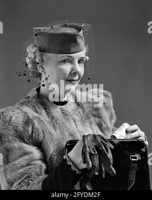 ANNÉES 1940 FEMME ÉLÉGAMMENT HABILLÉE REGARDANT L'APPAREIL PHOTO PORTANT UN CHAPEAU VOILE VESTE COURTE EN FOURRURE TENANT DES GANTS SAC À MAIN ET WAD OF ESPÈCES - S7507 HAR001 HARS STUDIO TOURNÉ MAISON VIE LUXE ESPACE DE COPIE FEMMES PERSONNES RISQUE VOILE CONFIANCE ADULTE SENIOR MOYEN-ÂGE B&W CONTACT VISUEL FEMME SÉNIOR TENTATION RÊVES VIEILLESSE MOYEN-ÂGE FEMME OLDSTERS TÊTE ET ÉPAULES OLDSTER ET RICHESSE SLY FIERTÉ OPPORTUNITÉ HAUT DE GAMME ANCIENS CONCEPTUELS RICHES ÉCHAPPER ÉLÉGAMMENT À L'ÉLÉGANT WAD BANK ROULER BIEN-À-FAIRE NOIR ET BLANC DE RACE BLANCHE HAR001 OLD FASHIONED Banque D'Images