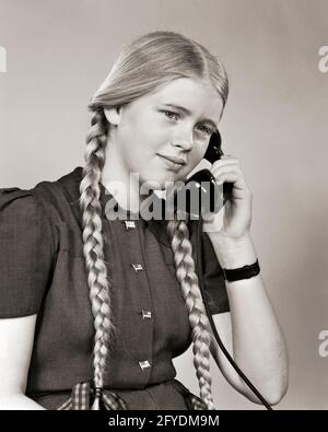 ANNÉES 1930 UNE ADOLESCENTE BLONDE DES ANNÉES 1940 AVEC DE TRÈS LONGUES TRESSES PARLANT SUR TÉLÉPHONE - T1016 HAR001 HARS CONNEXION TÉLÉPHONIQUE TRÈS RÉSEAU TÉLÉPHONES ÉLÉGANTS JEUNES ADOLESCENTS JEUNES JEUNES RACE NOIR ET BLANC ORIGINE ETHNIQUE CAUCASIENNE HAR001 À L'ANCIENNE Banque D'Images