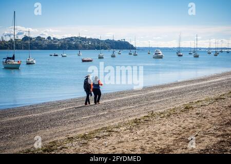 AUCKLAND, NOUVELLE-ZÉLANDE - 19 mai 2021 : deux femmes marchant le long de la plage de Bucklands. Auckland, Nouvelle-Zélande - 13 mai 2021 Banque D'Images