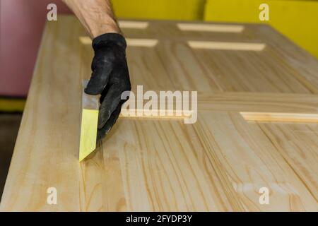 Main de travail dans le gant de ponçage avec bloc de ponçage porte en bois Banque D'Images