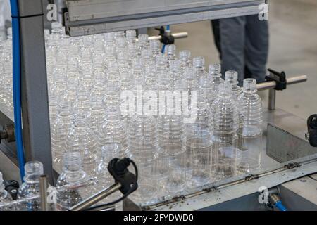 Les différents types de bouteilles en plastique et de préforme avec arrière-plan du moule d'injection. Traitement de fabrication de récipients à boire. Banque D'Images