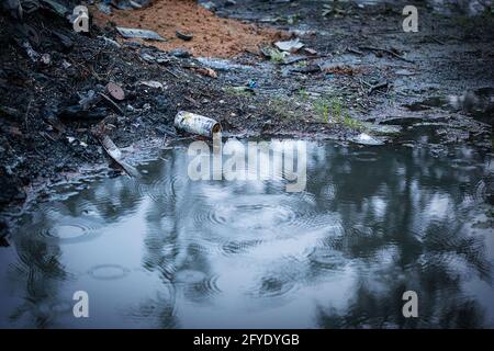 déchets brûlés autour d'une flaque de pluie Banque D'Images