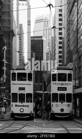 Deux trams blancs côte à côte à un arrêt dans la ville de Hong Kong. Ils sont souvent appelés « trams de dégrissement » en raison du son de leur cloche. Banque D'Images