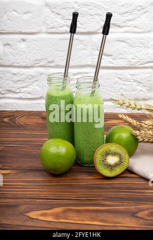 Smoothie aux fruits verts fraîchement mixés dans un bol en verre avec paille. Banque D'Images