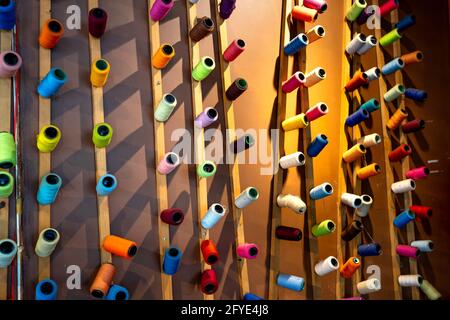 Décorez les bobines colorées de fil sur le mur à un café Banque D'Images