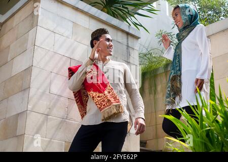 L'homme musulman d'Asie aller au travail en laissant la femme au foyer femme portant un costume traditionnel Banque D'Images