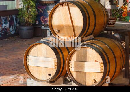 Trois fûts de vin ou de whisky en bois sur la rue. Les fûts sont empilés les uns sur les autres. Banque D'Images