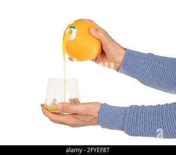 Jus d'orange versé dans le verre, directement hors de l'orange Banque D'Images