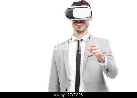 Portrait horizontal moyen de jeune homme d'affaires caucasien joyeux adulte portant une combinaison grise avec un casque VR, fond blanc Banque D'Images