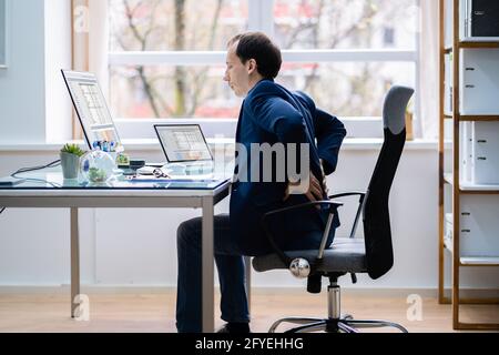 Mauvaise posture douleur au dos dans la chaise de bureau Banque D'Images