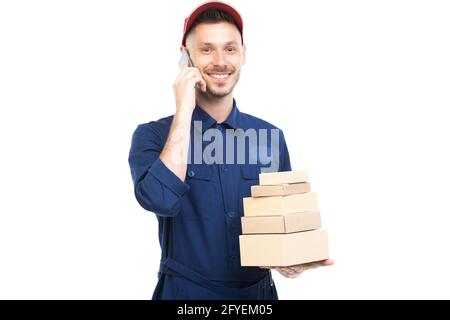 Portrait horizontal moyen d'un jeune adulte élégant de race blanche liveur portant des boîtes de maintien bleu uniforme à l'aide d'un smartphone, fond blanc Banque D'Images
