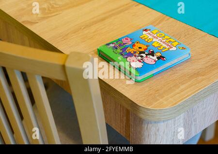 POZNAN, POLOGNE - 18 avril 2015: Livre coloré de bébé couché sur une table en bois Banque D'Images