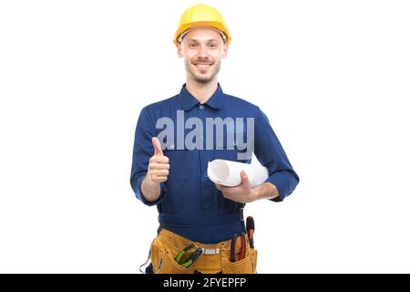 Portrait horizontal moyen d'un jeune homme de race blanche confiant portant un uniforme bleu tenant le plan de construction, fond blanc Banque D'Images