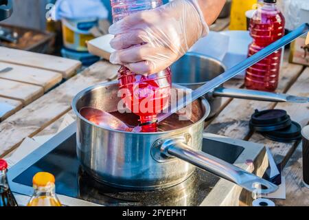 Jus de baies à base de fraises fraîches ou de canneberges - une boisson pour étancher votre soif est préparée sur le comptoir d'un vendeur de rue. Fête de la gastronomie dans Banque D'Images