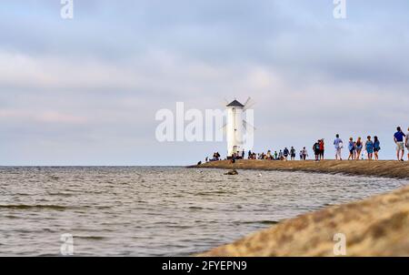 Les gens marchent vers le phare de la mer Baltique à Swinoujscie en Pologne. Banque D'Images