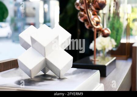 forme polygonale en céramique blanche placée sur le livre dans salon pour la décoration Banque D'Images