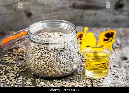 Huile de tournesol et graines de tournesol en pot sur table en bois Banque D'Images