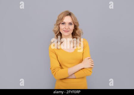 joli look de jeune fille souriante. femme blonde a croisé les mains. portrait de femme blonde. Banque D'Images