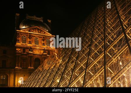 Die Hell erleuchtete Glaspiramide des Pariser Musées du Louvre strahlt in Paris dans le Nacht Banque D'Images