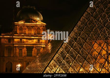 Die Hell erleuchtete Glaspiramide des Pariser Musées du Louvre strahlt in Paris dans le Nacht Banque D'Images